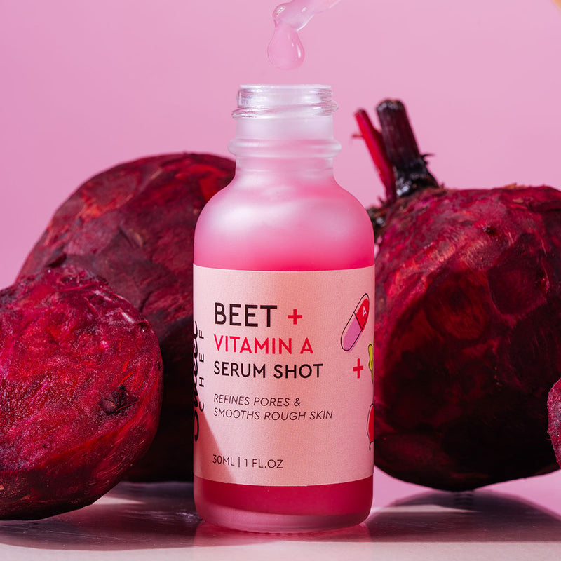 pink serum inside a clear glass bottle surrounded by beets 